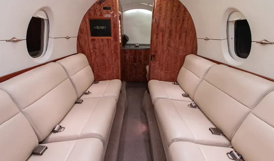 The interior of a Citation jet with cream-colored leather seats.