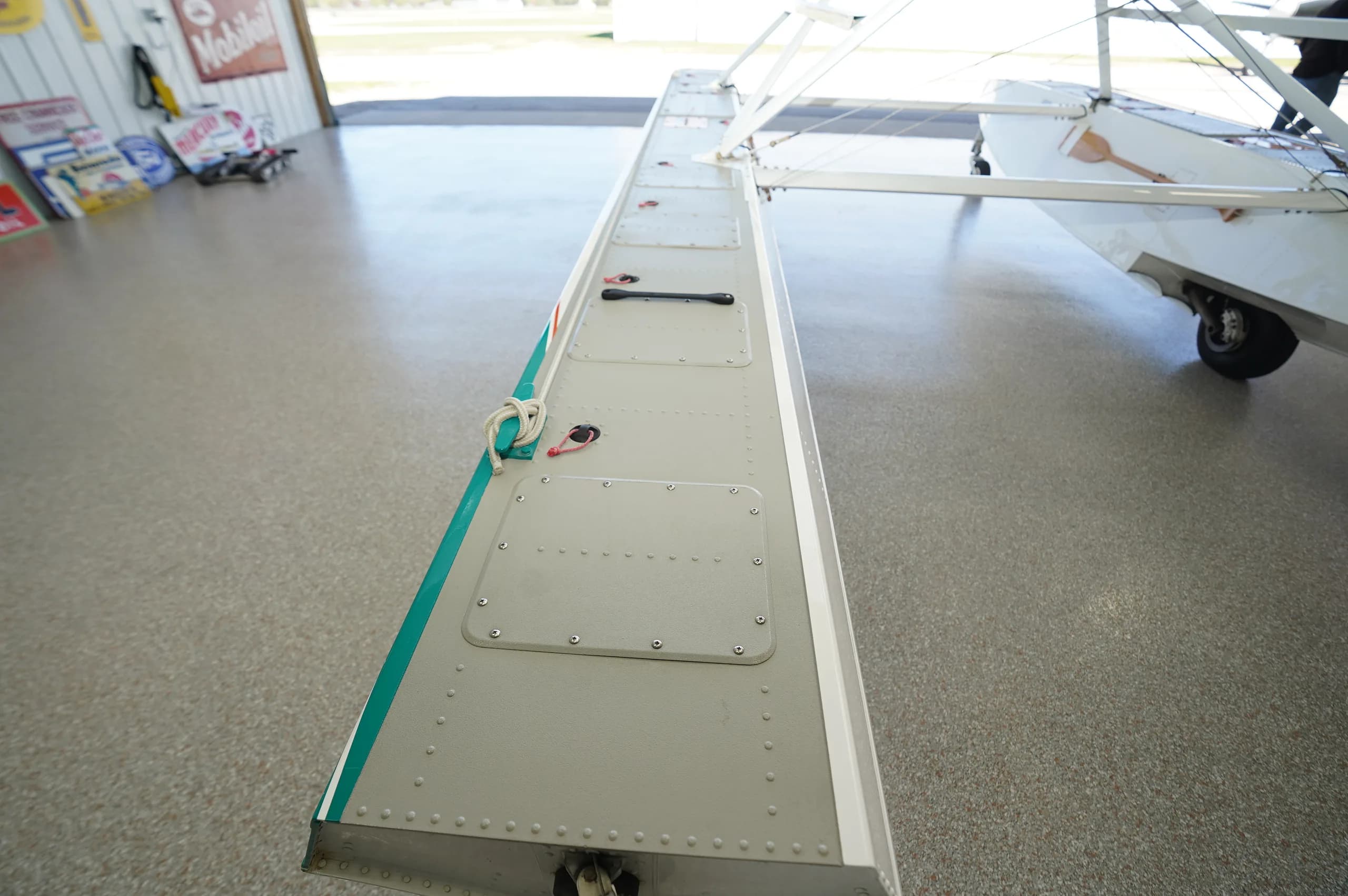 Top-down view of the aircraft's white float with teal stripe and access panels.