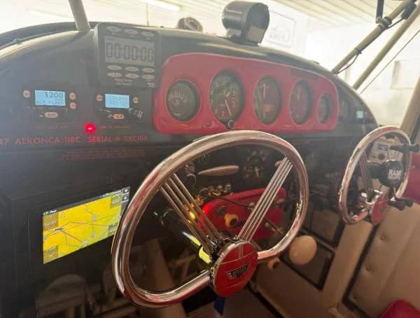 The cockpit of a 1947 Aeronca 11BC aircraft, featuring a classic-style yoke, analog gauges, and a modern digital display.