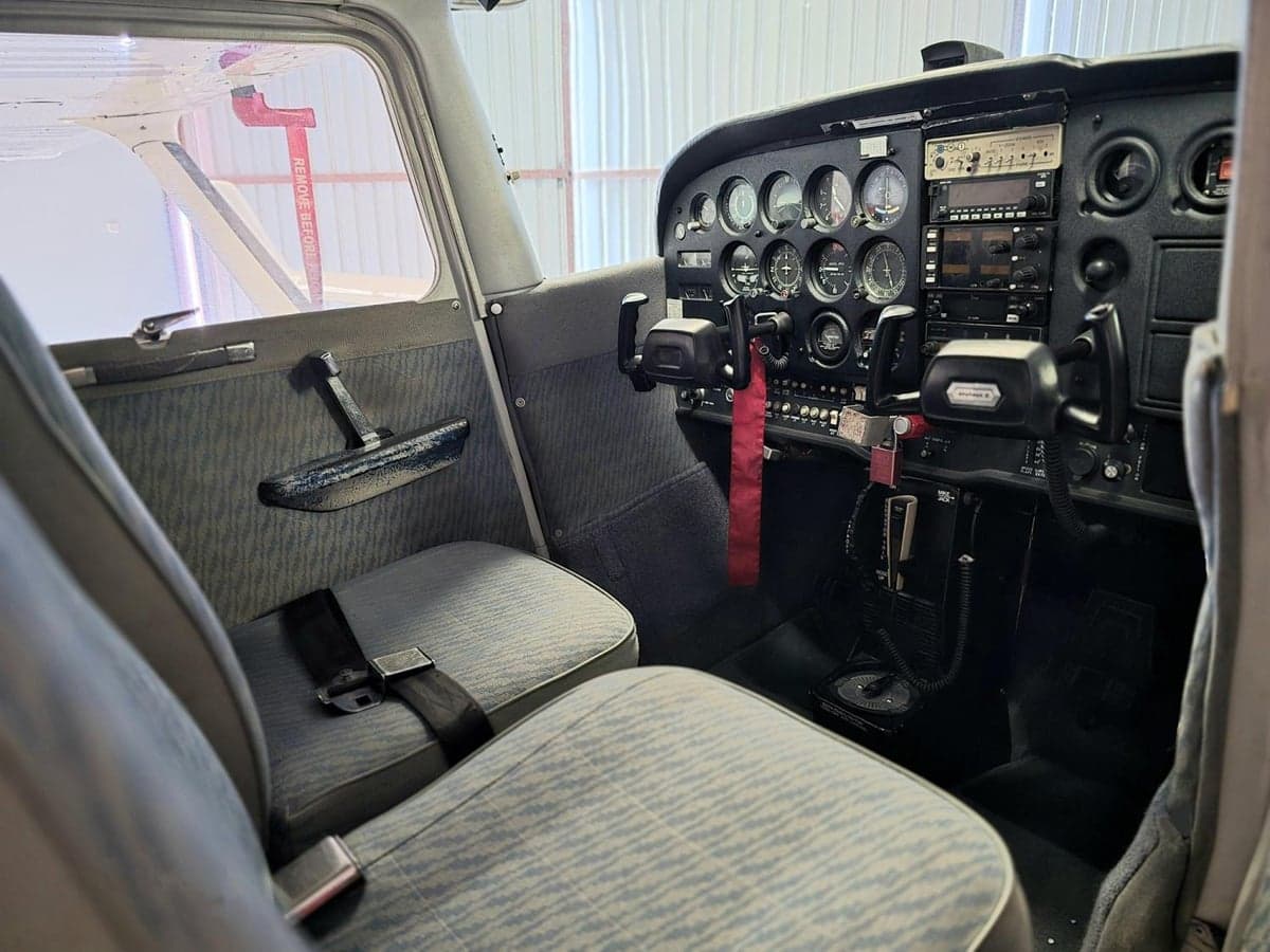 The cockpit of a Cessna aircraft, showing the instrument panel and seats.