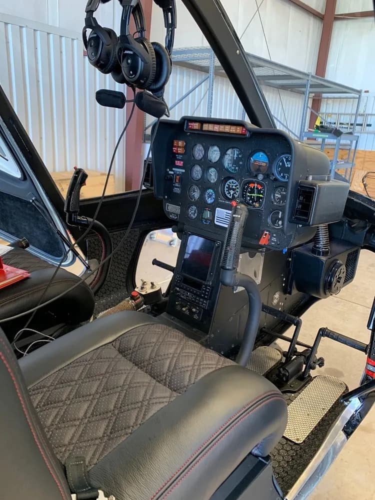 View of the cockpit of the Bell 206L-4 helicopter, showing the instrument panel and seats.