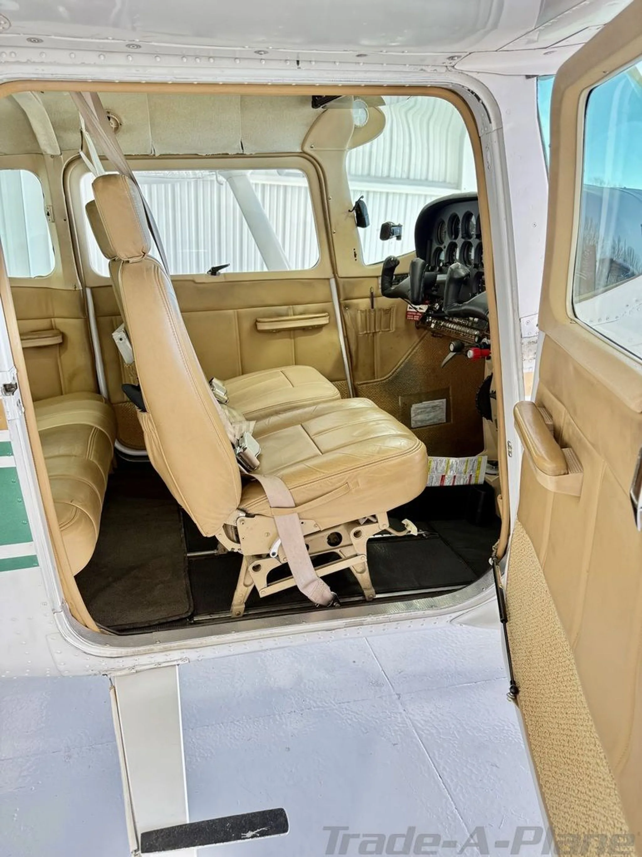 The tan leather interior of the aircraft, showing the front seats and a partial view of the cockpit.