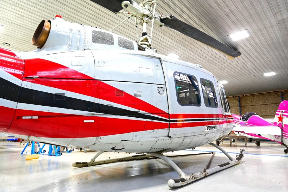 Side view of the N857SD helicopter in a hangar.