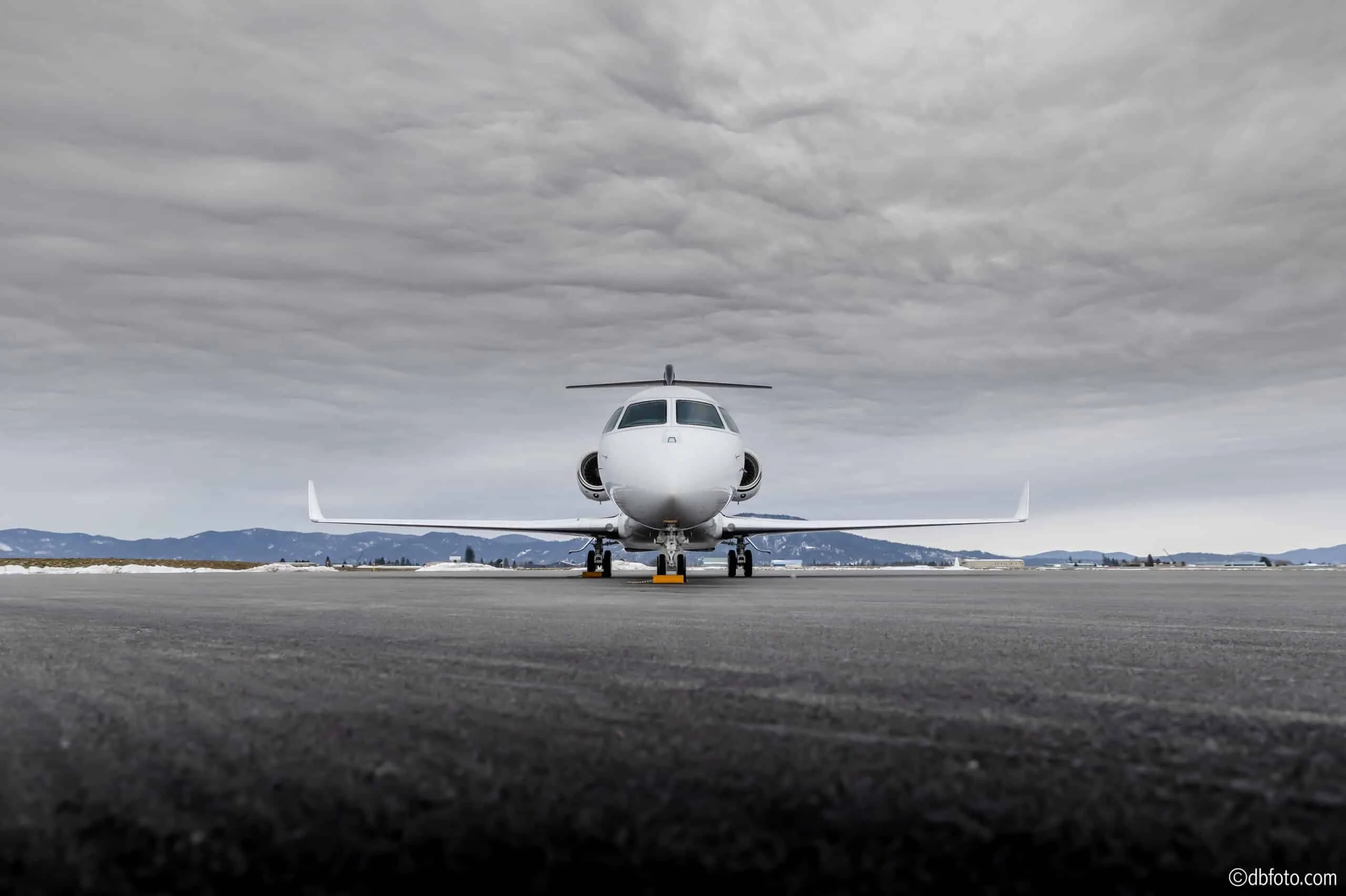 A head-on view of the white Gulfstream G550 (or similar large business jet) N280HL parked on a tarmac.