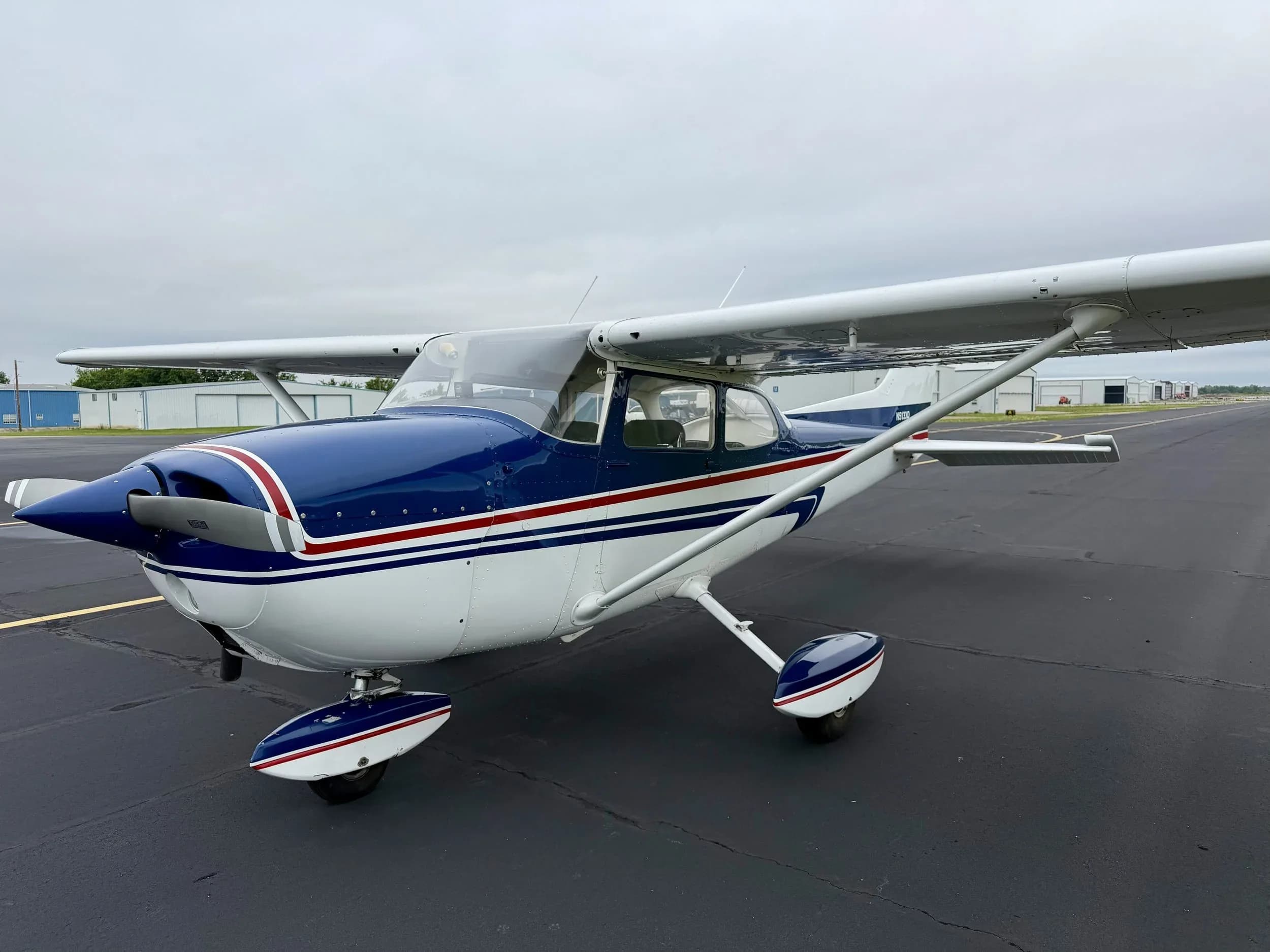 A slightly different front-quarter view of the blue and white Cessna 172 aircraft N5133Q on the tarmac.