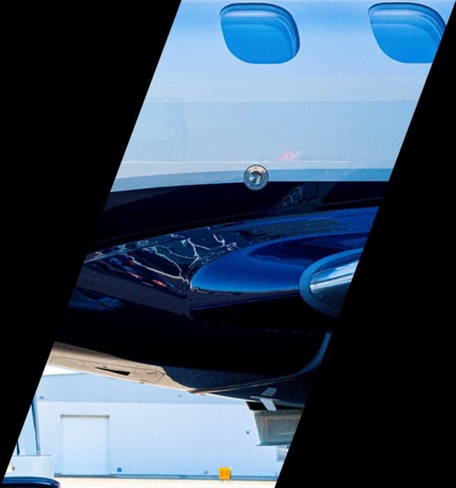 Close-up of the underside of a dark blue and white jet fuselage.