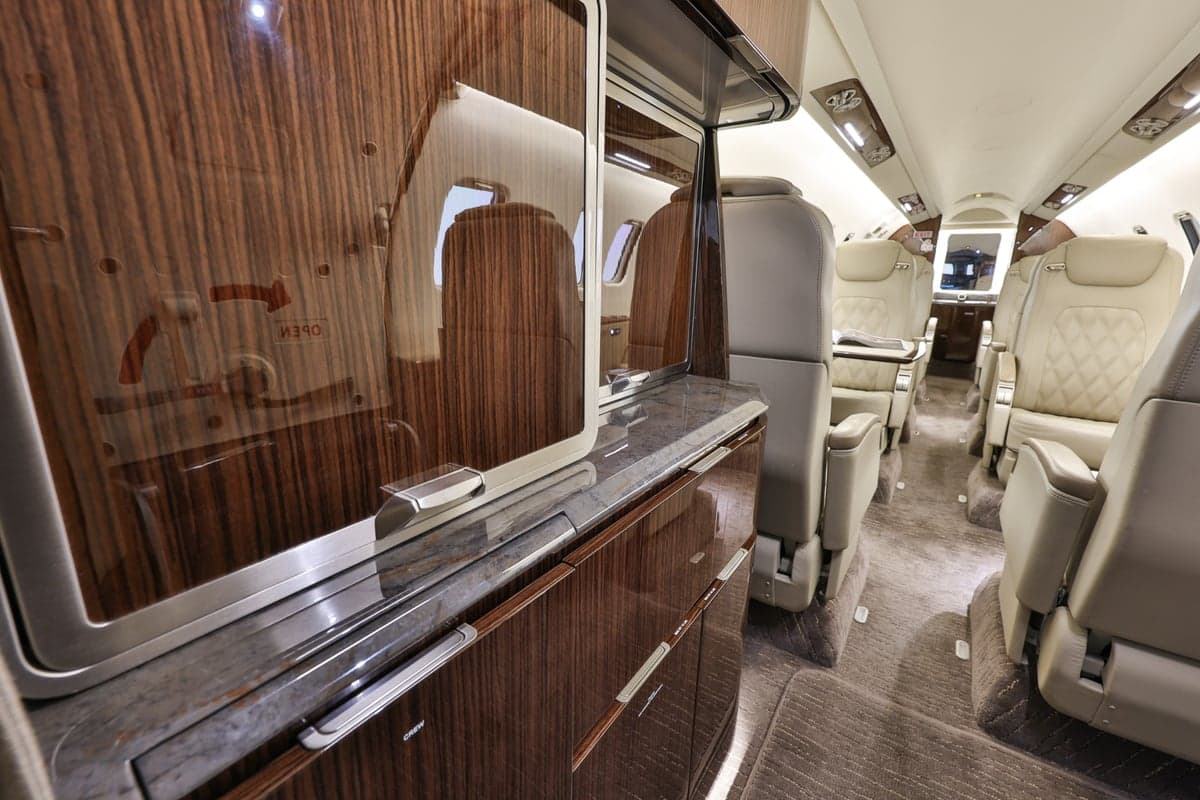 View of the Learjet 45XR interior with seating and cabinetry.
