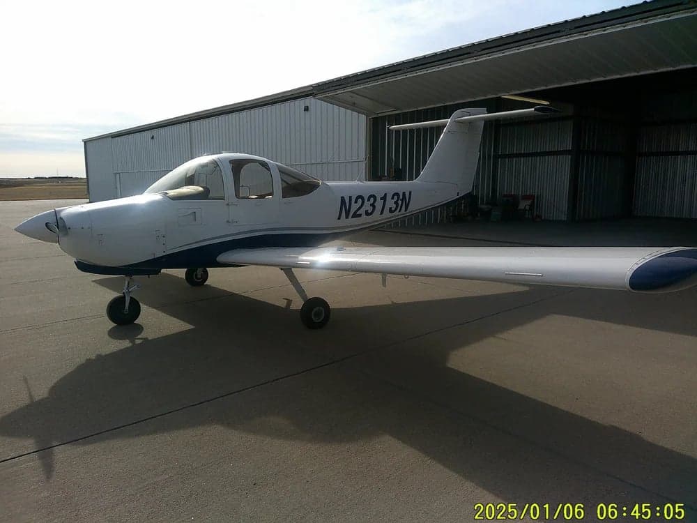 Side view of aircraft N2313N parked outside a hangar.