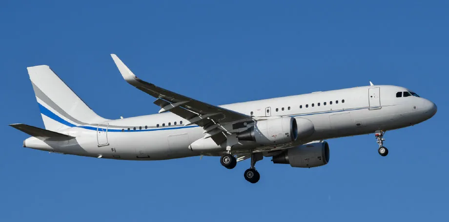 A white Airbus A319 with blue and grey stripes on the tail and fuselage is in flight against a clear blue sky, with landing gear extended.