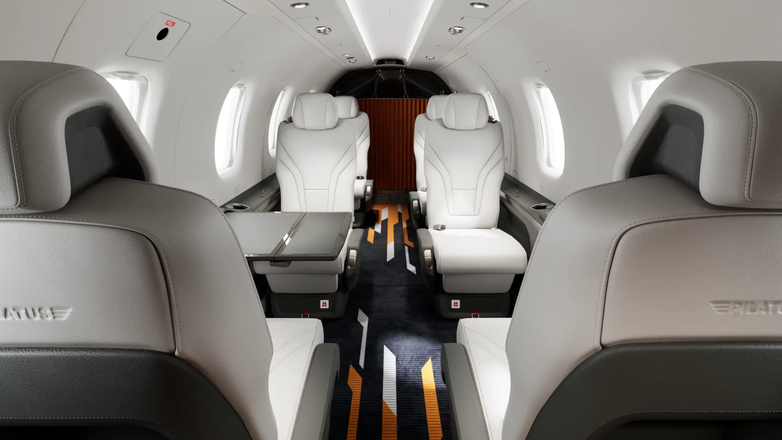 View of the aircraft's interior showing the white leather seats and a table.