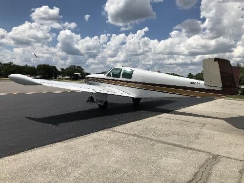 A Beechcraft Bonanza sits on the tarmac with the tail number N8565A visible.