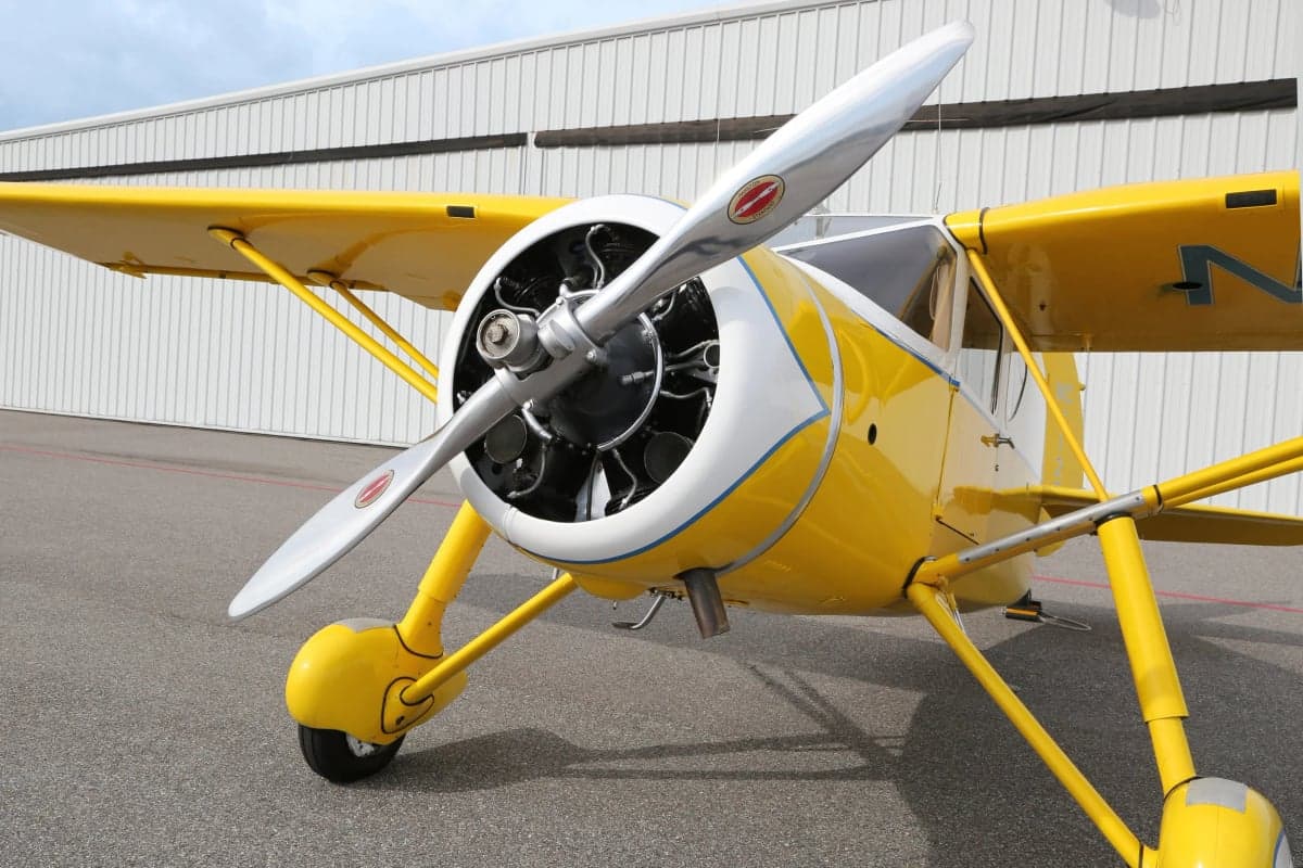 Close up of a yellow and white Stinson Reliant's engine and propeller.