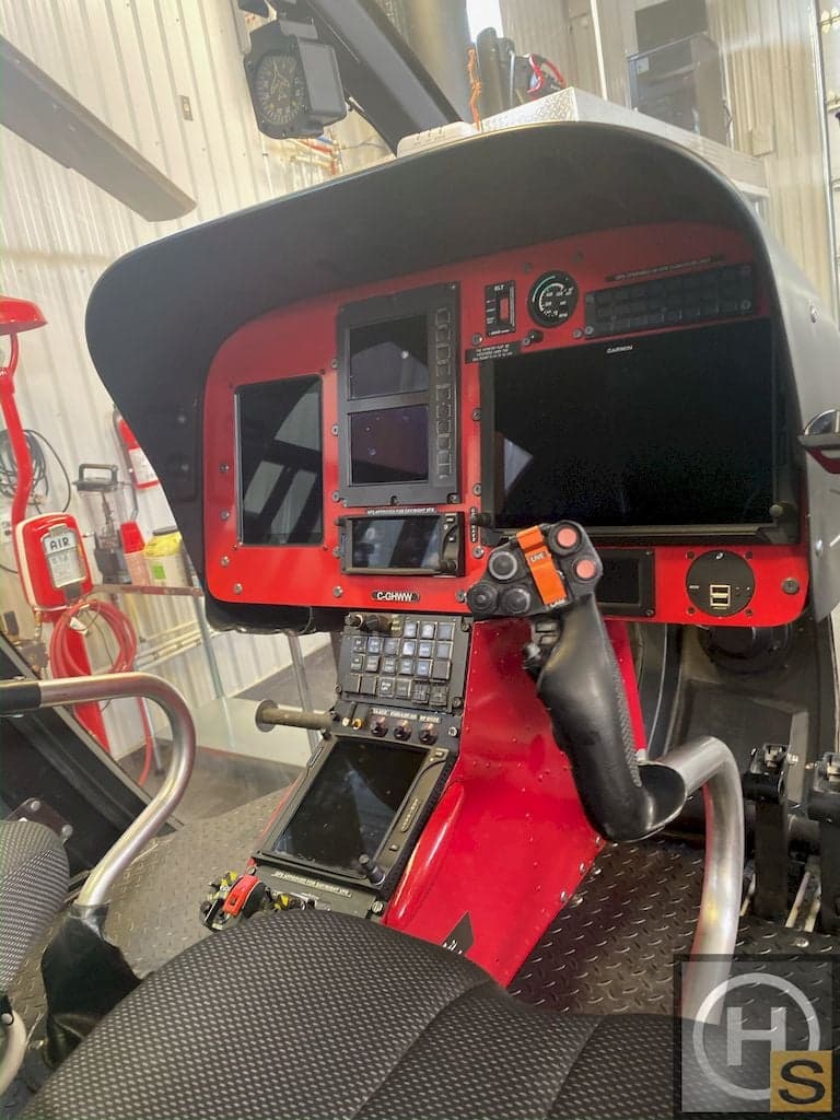 The helicopter's instrument panel features multiple screens and controls.