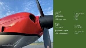 Close-up of the propeller and engine cowling of a Cirrus SR22G6 aircraft, with aircraft details listed.