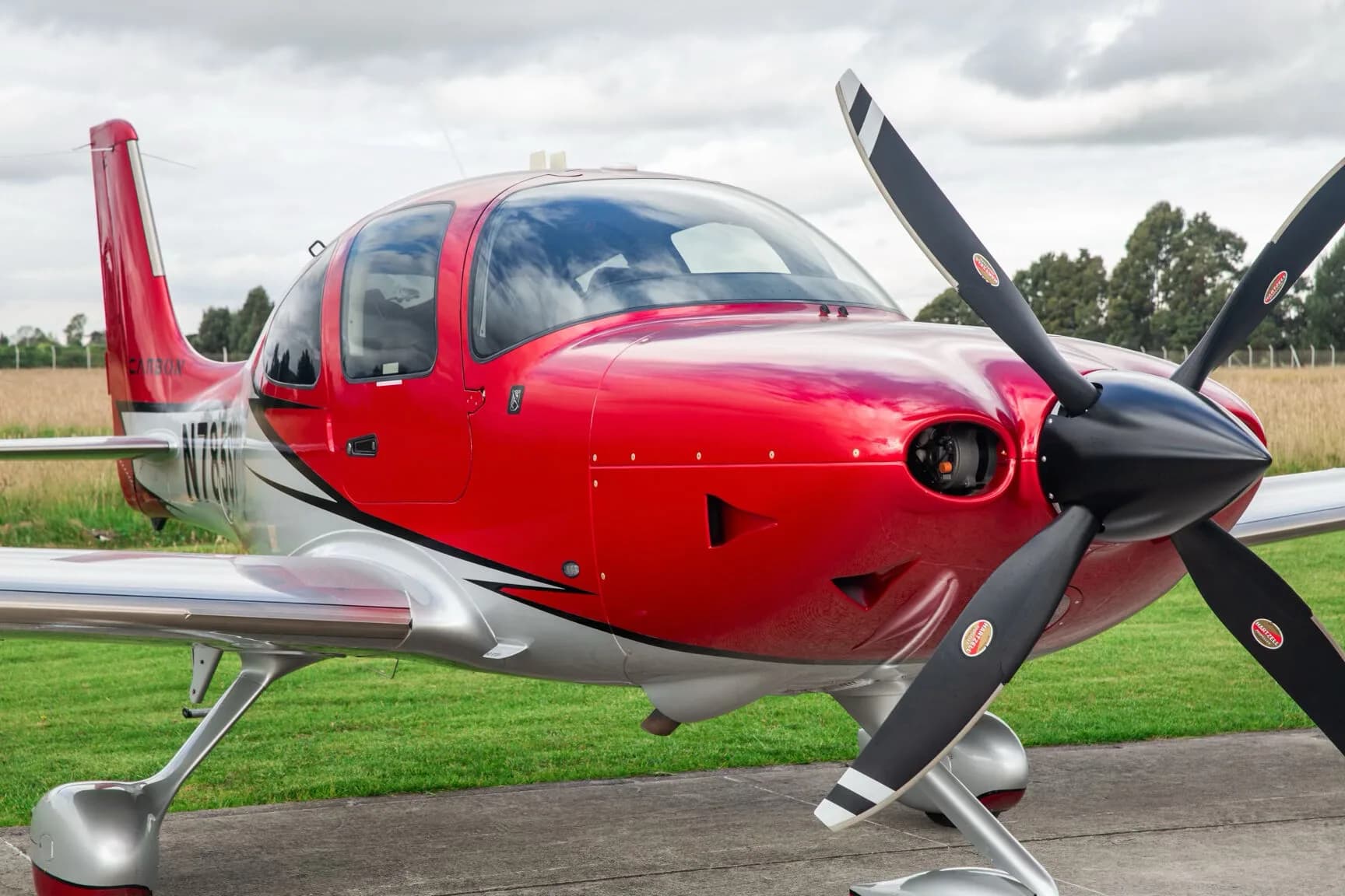 Close-up of the red nose and black propeller of the Cirrus SR22T aircraft.