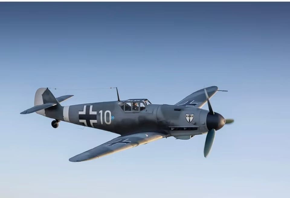 A gray Messerschmitt Bf 109 aircraft in flight.
