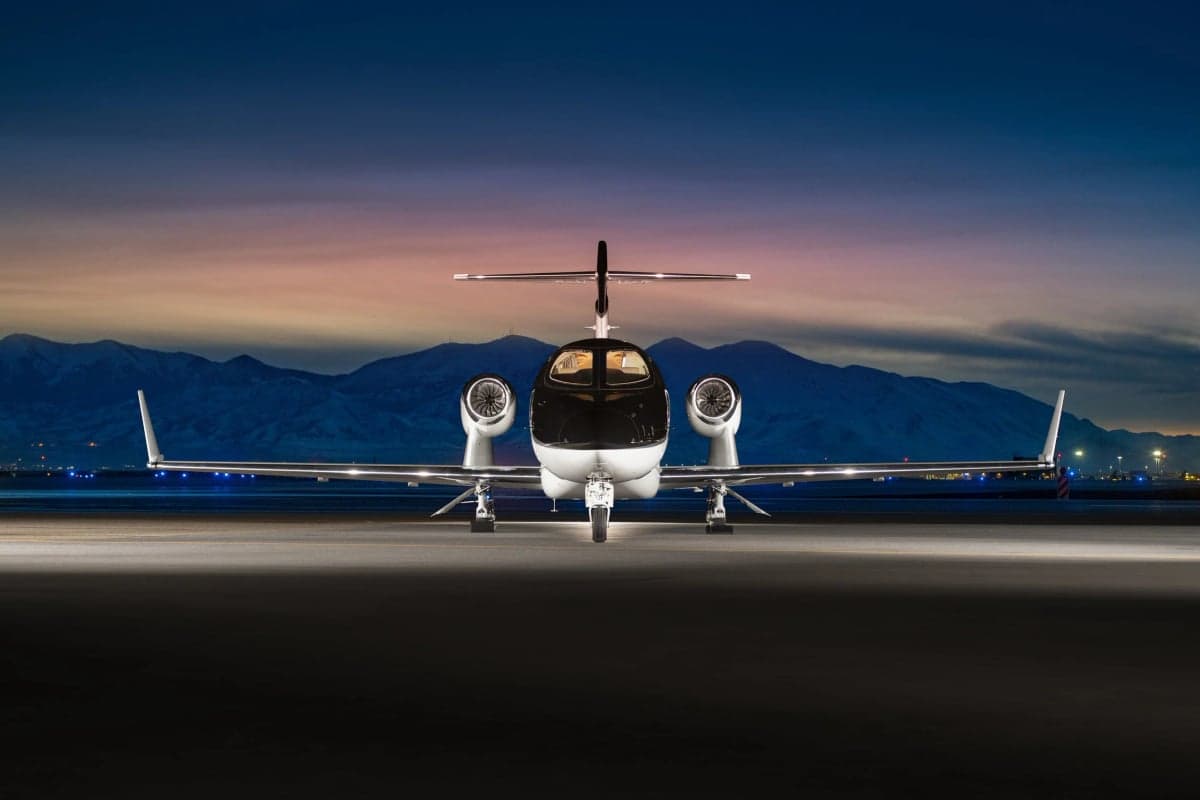 Front view of a HondaJet on the tarmac at dusk.