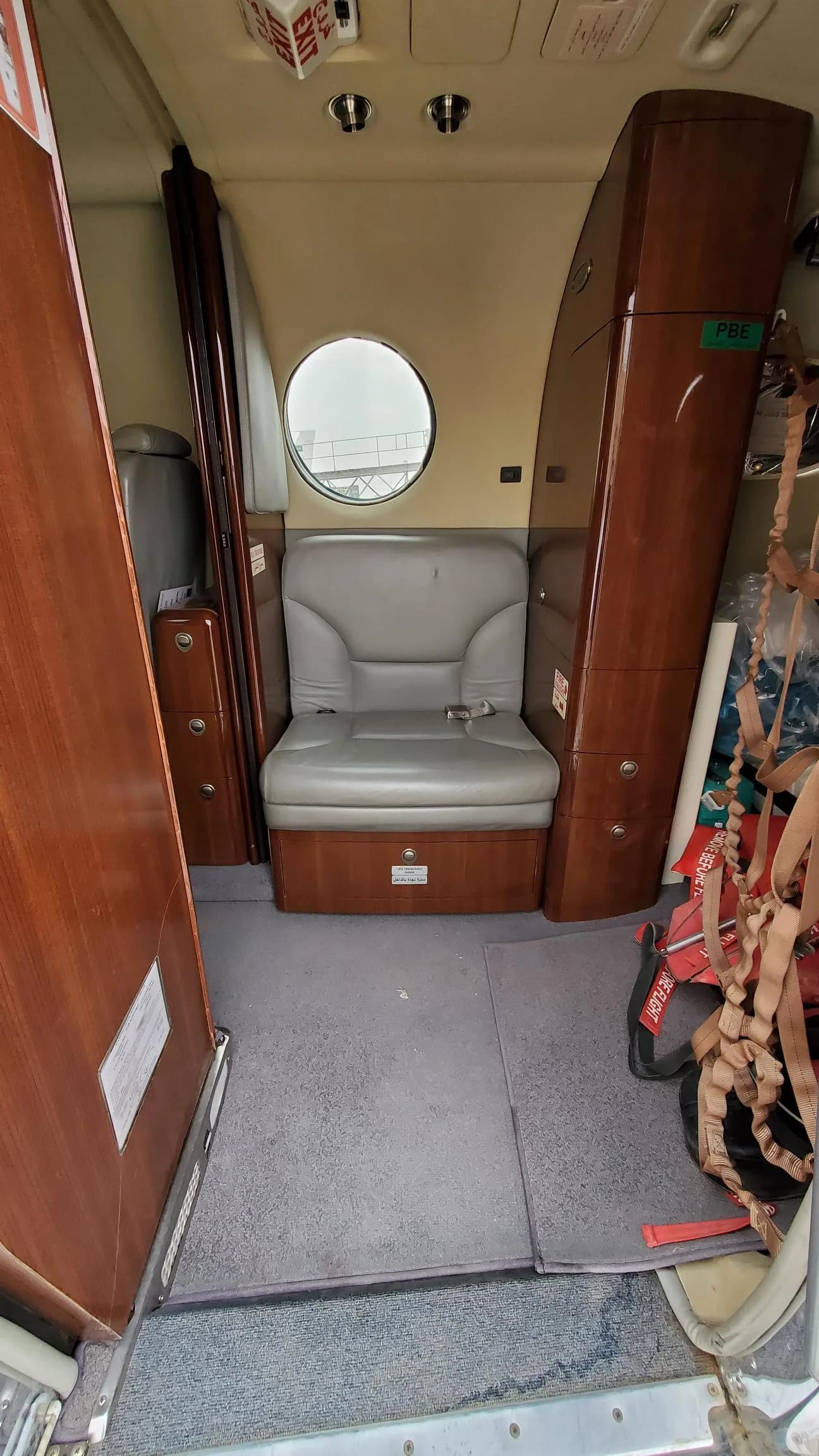 View of the aircraft's cabin with a single seat and wooden cabinetry.