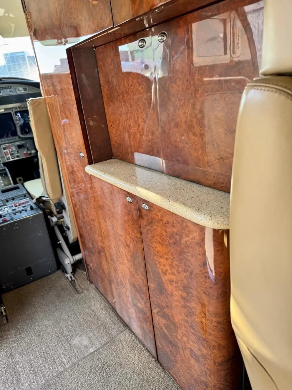 View of the aircraft interior with wood paneling and a shelf.