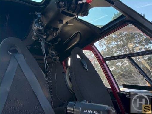 The helicopter's interior features black seats and a view of the sky.