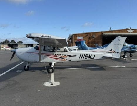 Cessna 172 Skyhawk N15MJ parked in front of a hangar.
