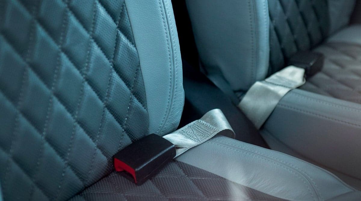 Close-up of the quilted leather seats and seatbelts in the cabin of the aircraft.