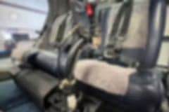 Interior view of the helicopter cabin with seats and blankets.