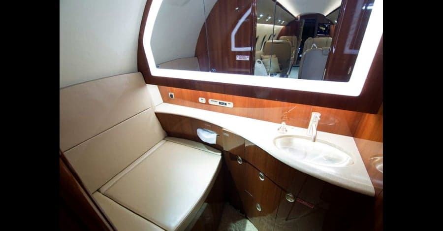Lavatory with sink and seating in the aircraft.