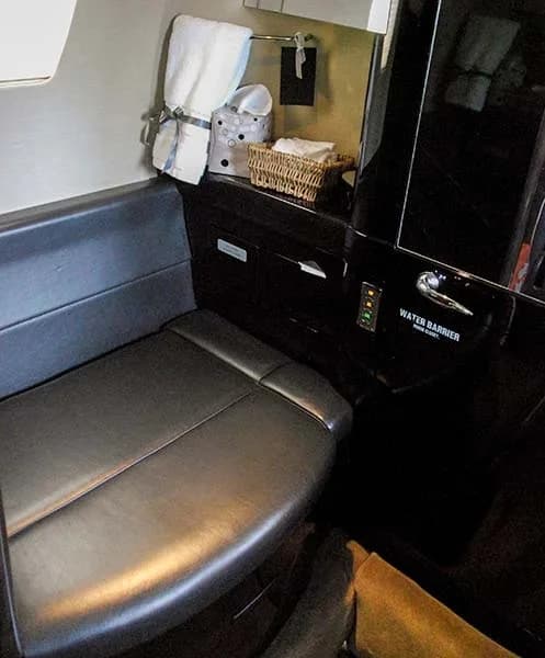 Aircraft lavatory with seat and amenities.