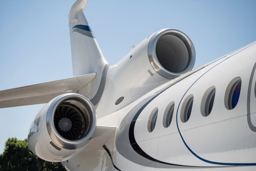 Close up of the tail and engines of the white aircraft.