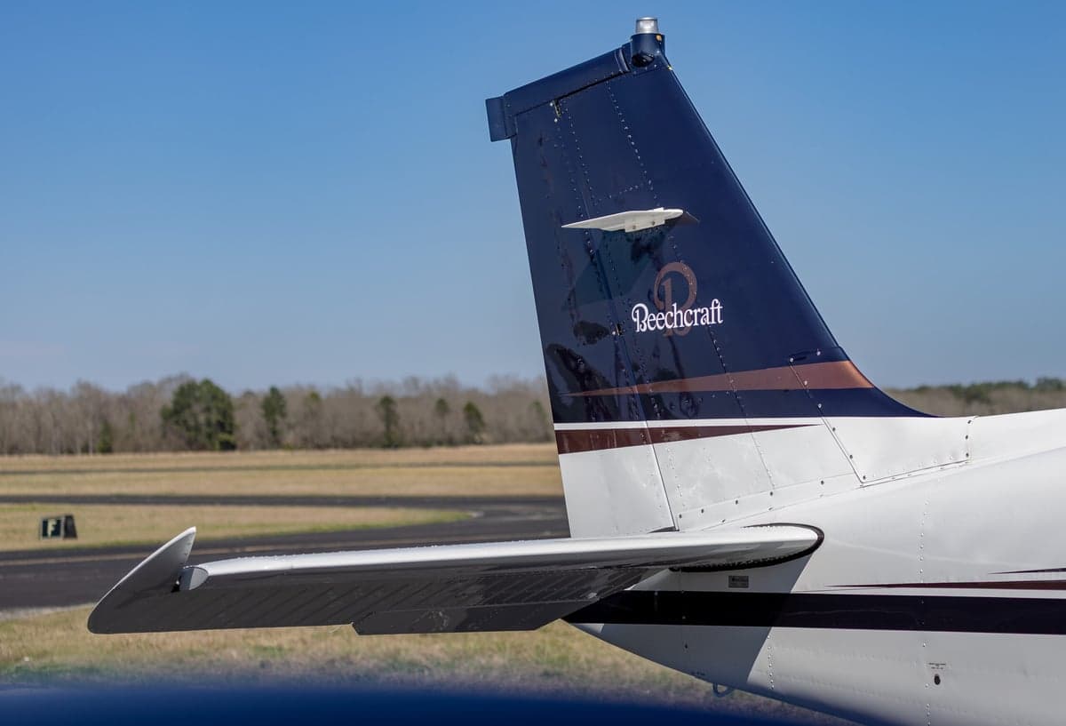 Close up of the tail of the Beechcraft Bonanza N219DK showing the Beechcraft logo.