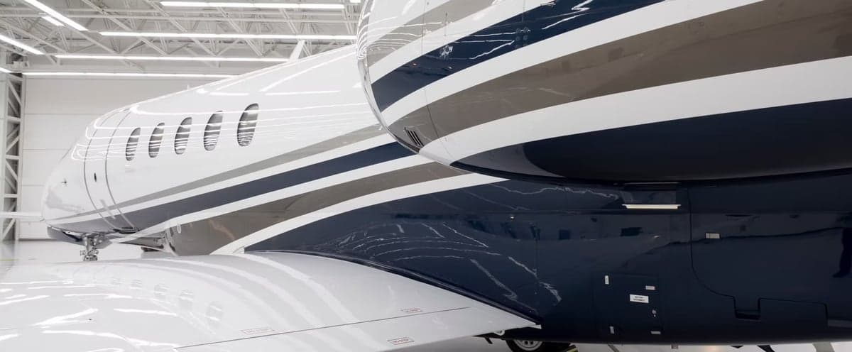 Close-up of the tail and fuselage of a Cessna Citation Latitude with a white, gray, and blue paint scheme.