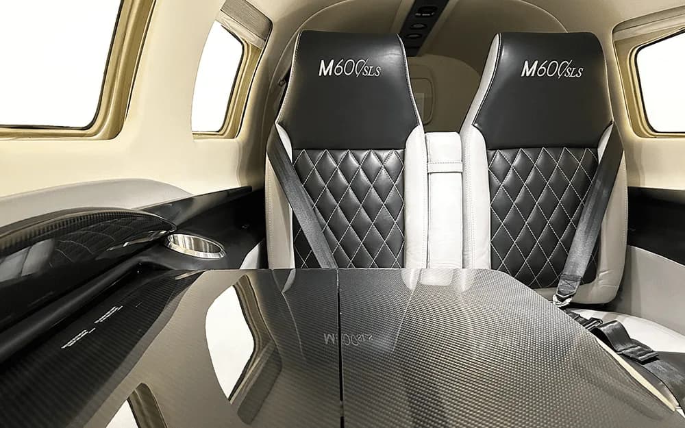 A view of the Piper M600/SLS cabin interior, showing the rear seats and a folded carbon fiber table.