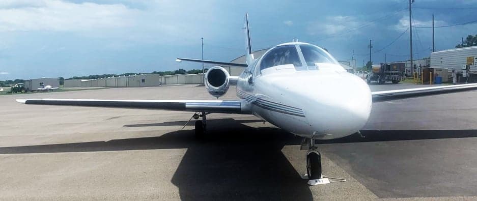 Front view of a white Cessna CitationJet on the tarmac.