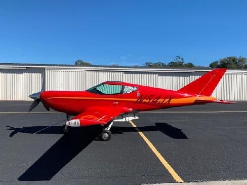 Side view of a red aircraft with registration N54JX on the tarmac.