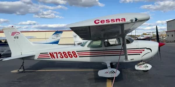 A white and dark blue Cessna aircraft with grey stripes, registration N75829, parked on an tarmac.
