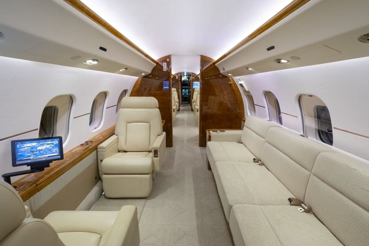 A view of the aircraft's interior with cream-colored leather seats and a couch.