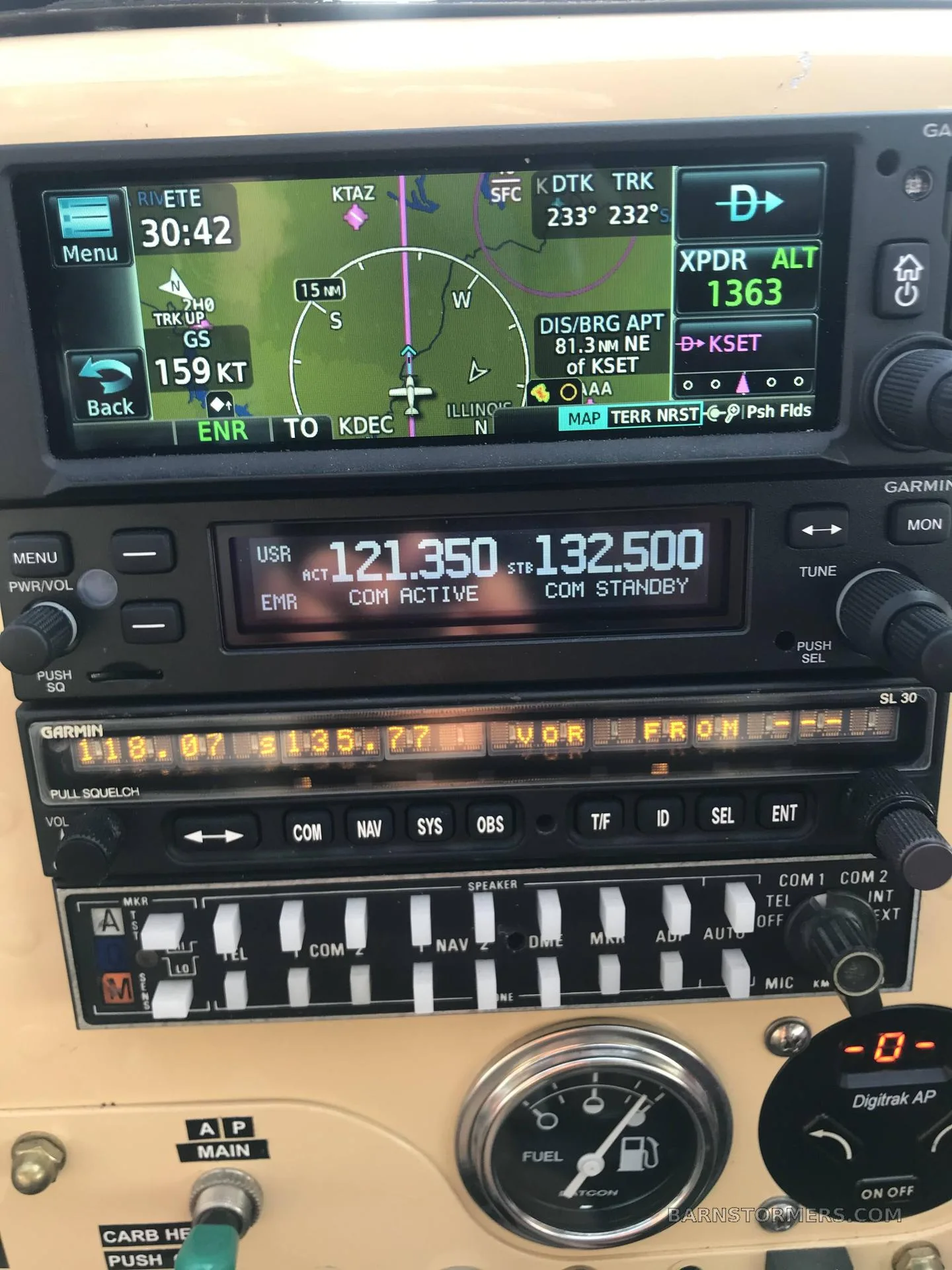 A close-up view of the aircraft's avionics stack, displaying GPS navigation and radio frequencies.