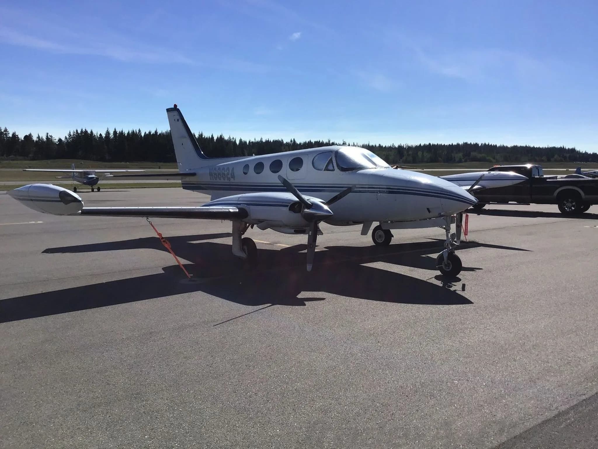 A front-quarter view of the white and blue twin-engine Cessna 340 aircraft, N98624, parked on an airfield.