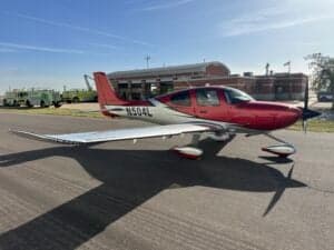 Side view of a Cirrus SR22T aircraft with a red and silver paint scheme, showing the registration number N504L.