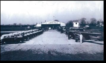 Black and white photo of Norton Field with a line of aircraft and vehicles.