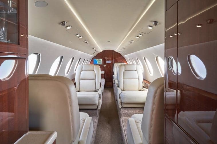 Interior view of the aircraft cabin with cream-colored leather seats.