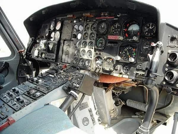 A close-up view of a helicopter cockpit with numerous gauges and controls.