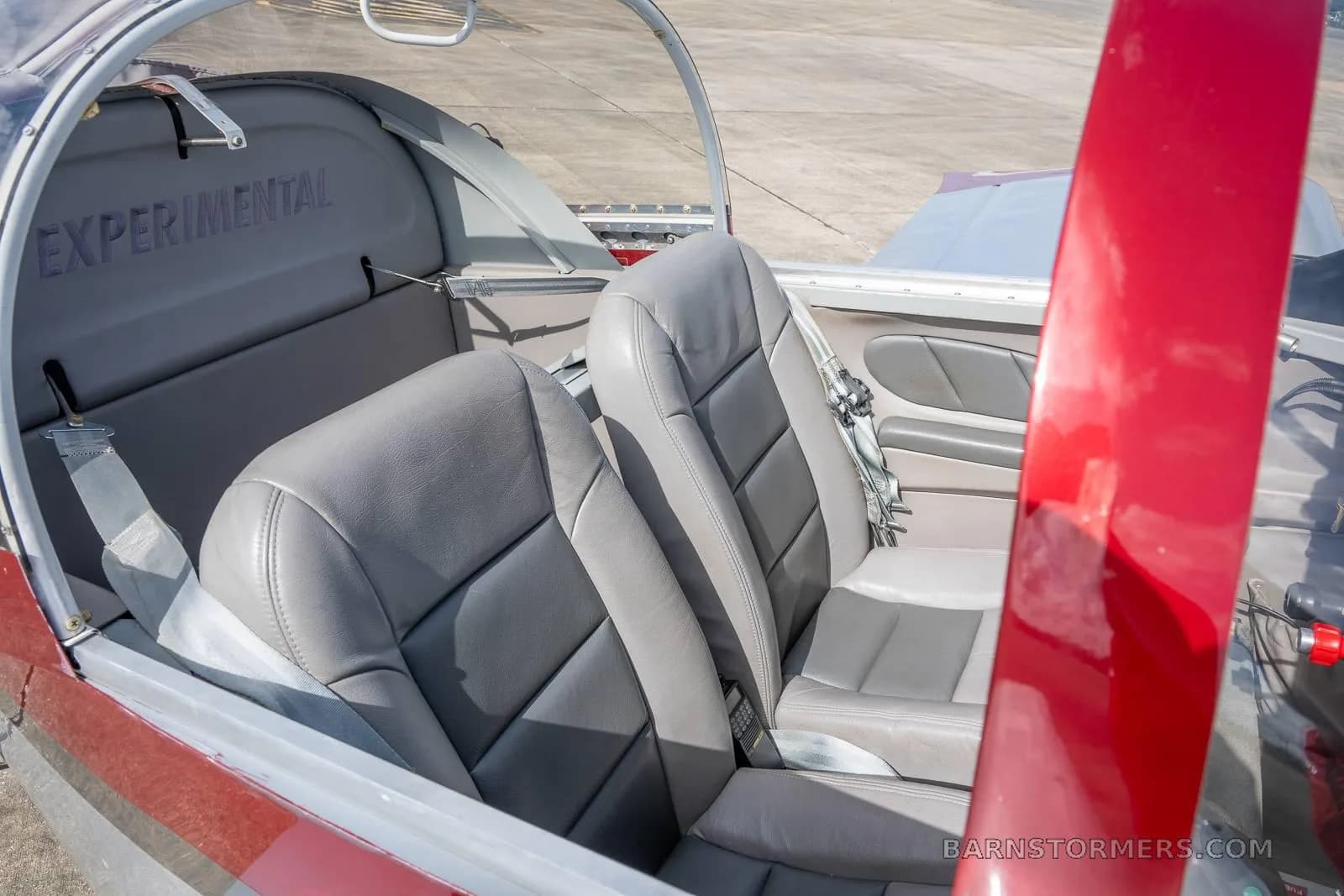 The gray leather seats and interior cabin of the experimental aircraft, with "EXPERIMENTAL" visible on the rear bulkhead.