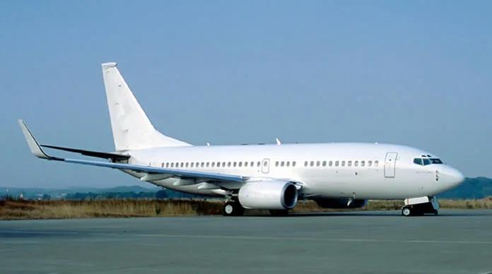 A white jet aircraft is parked on the tarmac.