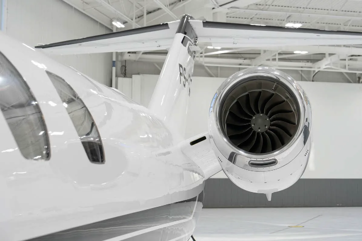 A close-up view of the polished engine intake and tail section of a white Cessna Citation CJ3 jet.