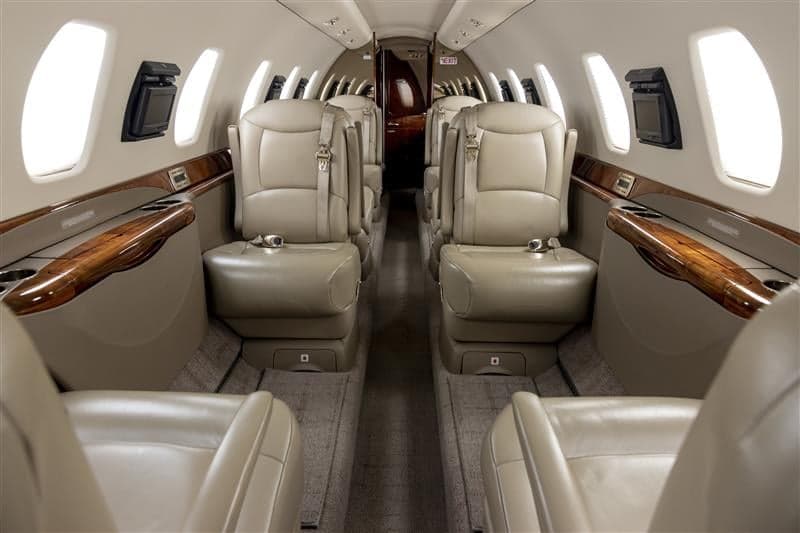 The aircraft's interior features leather seats and carpeted flooring.