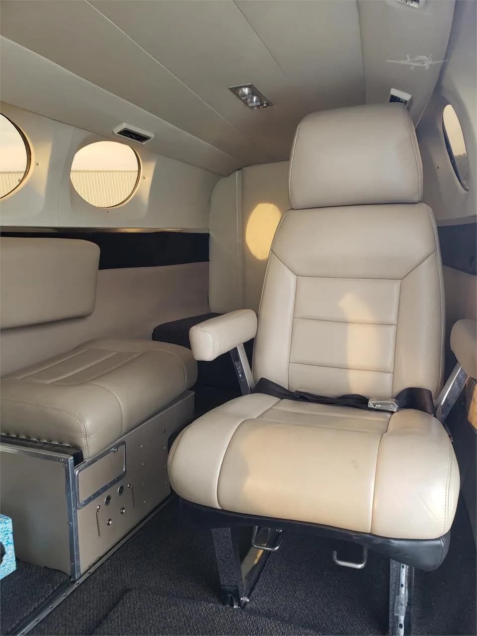 The interior of the aircraft features tan leather seats and round windows.