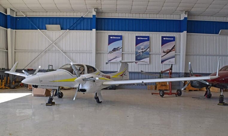 Diamond DA62 aircraft parked inside a hangar with Diamond Aircraft banners.