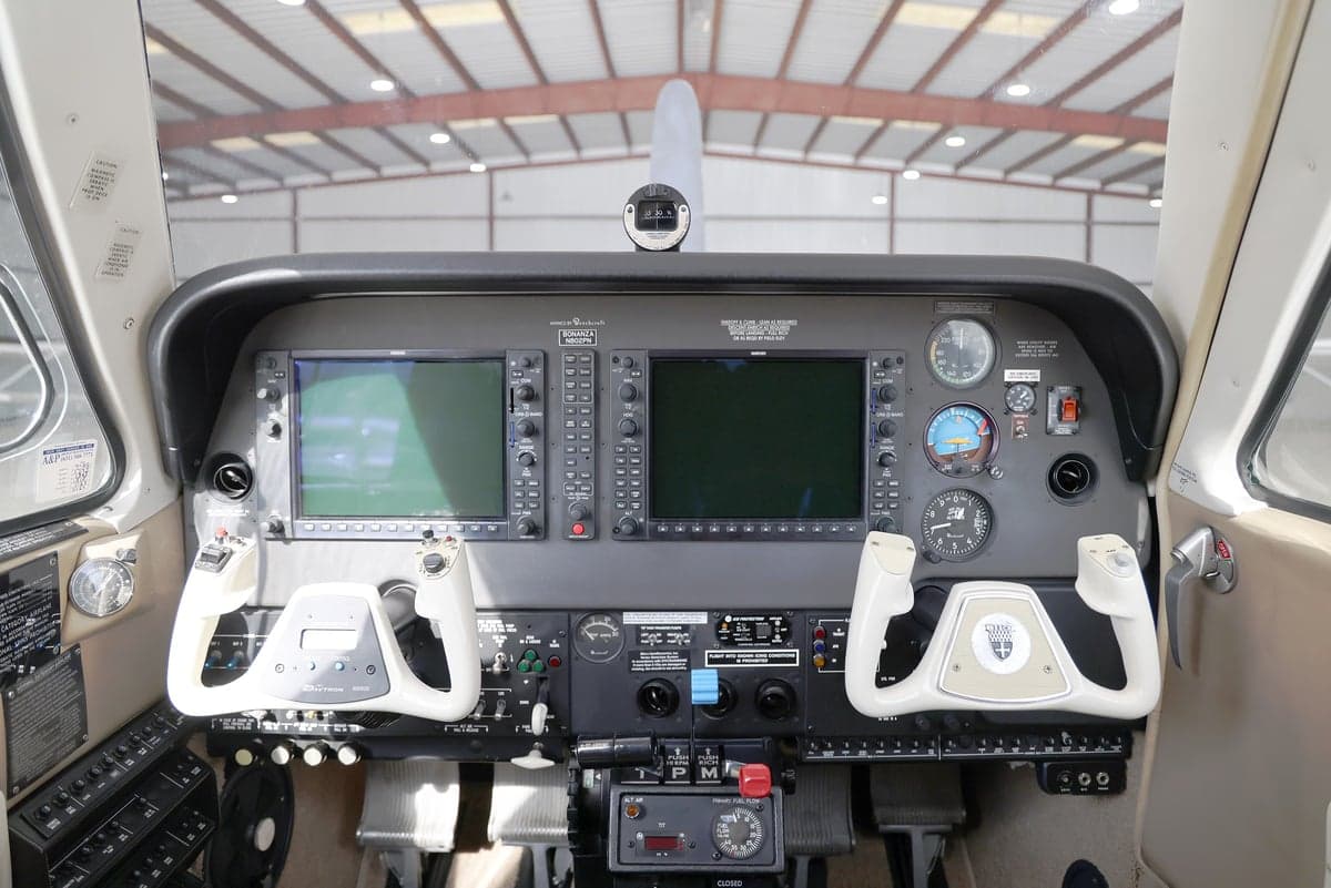 View of the cockpit of a Beechcraft Bonanza N802PN, showing the instrument panel with two large displays and control yokes.